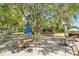 Outdoor area with tables, seating, and a stage surrounded by lush trees and partial shade at 20861 Sw 81St Loop, Dunnellon, FL 34431