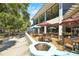 Inviting outdoor seating area with umbrellas, tables, and chairs overlooking the landscaped grounds and a long building at 20861 Sw 81St Loop, Dunnellon, FL 34431