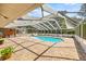 Screened-in pool with an attached spa, brick flooring and lounge chairs to relax in the sun at 20861 Sw 81St Loop, Dunnellon, FL 34431