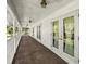 Inviting covered porch with white columns, railings, and multiple doors with outside view at 20861 Sw 81St Loop, Dunnellon, FL 34431