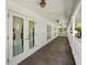 Inviting covered porch with white columns, railings, and multiple doors with outside view at 20861 Sw 81St Loop, Dunnellon, FL 34431