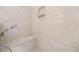 Close-up of a modern shower featuring a built-in bench, rainfall showerhead, and unique stone wall at 20861 Sw 81St Loop, Dunnellon, FL 34431