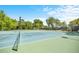 Well-maintained tennis court on a sunny day, surrounded by trees, promoting an active lifestyle at 20861 Sw 81St Loop, Dunnellon, FL 34431