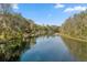 Scenic waterway with lush trees on either side offers peaceful views and boating opportunities at 20861 Sw 81St Loop, Dunnellon, FL 34431