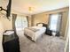 Bedroom with a ceiling fan, sliding doors, and curtains beside the window at 21298 Sw Peach Blossom St, Dunnellon, FL 34431