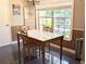 Charming dining area with a wooden table set, natural light, and view from the window at 21298 Sw Peach Blossom St, Dunnellon, FL 34431
