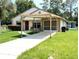 Lovely home featuring a covered carport, bright exterior, and a well-kept lawn at 21298 Sw Peach Blossom St, Dunnellon, FL 34431