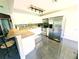 Bright kitchen featuring white cabinets, stainless steel appliances, and bar seating at 21298 Sw Peach Blossom St, Dunnellon, FL 34431