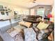 Cozy living room featuring a comfortable sofa, patterned chair, and view of the kitchen bar at 21298 Sw Peach Blossom St, Dunnellon, FL 34431