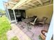 An outdoor patio features a grill, dining table with chairs, and a textured brick floor at 21298 Sw Peach Blossom St, Dunnellon, FL 34431