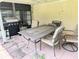 The covered patio has a dining set and grill at 21298 Sw Peach Blossom St, Dunnellon, FL 34431