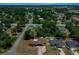 Wide aerial view of the property, its positioning within the community, and the mature trees that surround it at 23 Larch Crse, Ocala, FL 34480