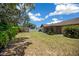 Expansive backyard featuring lush landscaping, mature trees, shed, and a screened-in lanai, perfect for outdoor living at 23 Larch Crse, Ocala, FL 34480
