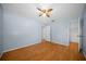 A cozy bedroom featuring light blue walls, hardwood flooring, and an open closet at 23 Larch Crse, Ocala, FL 34480