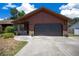 Close up of the home's facade, featuring a garage door and stone accents, complementing its architectural design at 23 Larch Crse, Ocala, FL 34480