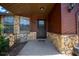 Inviting entryway with stone facade and a dark-colored front door, creating a warm and welcoming atmosphere at 23 Larch Crse, Ocala, FL 34480
