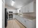 Well-lit kitchen with stainless steel appliances, white cabinets, and granite countertops at 23 Larch Crse, Ocala, FL 34480