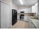 Modern kitchen featuring white cabinetry, granite countertops, stainless steel appliances, and modern flooring at 23 Larch Crse, Ocala, FL 34480
