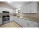 A modern kitchen with white cabinets, granite countertops, and stainless steel appliances at 23 Larch Crse, Ocala, FL 34480