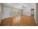 Bright living room featuring hardwood flooring, a ceiling fan, and large windows offering ample natural light at 23 Larch Crse, Ocala, FL 34480