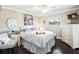 Bedroom with white furniture, a decorative mirror, and a serene window view at 2478 Nw 53Rd Avenue Rd, Ocala, FL 34482