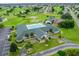 Aerial view of a community center featuring a pool, tennis courts, and manicured lawns next to a golf course at 2478 Nw 53Rd Avenue Rd, Ocala, FL 34482