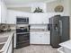 A kitchen with stainless steel appliances, white cabinets, and tile backsplash at 2478 Nw 53Rd Avenue Rd, Ocala, FL 34482