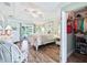 Bright bedroom with tray ceiling, wood floors, access to outdoor patio, and closet with clothing rack at 2478 Nw 53Rd Avenue Rd, Ocala, FL 34482