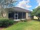 Home's backyard with well-kept lawn, landscaping, patio, and the home's neutral paint at 2515 Se 19Th Cir, Ocala, FL 34471