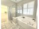 Bathroom features a soaking tub, glass shower, and natural light from a nearby window at 2515 Se 19Th Cir, Ocala, FL 34471