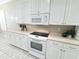 Functional kitchen with white cabinets, electric range, and plenty of counter space at 2515 Se 19Th Cir, Ocala, FL 34471