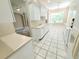 Bright kitchen featuring white cabinets, tile floors, and a large window overlooking the backyard at 2515 Se 19Th Cir, Ocala, FL 34471