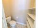Half-bathroom features a toilet, tile floors, neutral walls, and built in storage shelving at 2515 Se 19Th Cir, Ocala, FL 34471