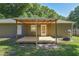 Backyard featuring a covered wooden deck, fire pit, and exterior door at 3065 Se 142Nd Ln, Summerfield, FL 34491