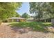 Expansive backyard featuring a wooden fence, mature shade trees, and a covered deck at 3065 Se 142Nd Ln, Summerfield, FL 34491