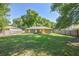 Expansive backyard featuring a wooden fence, mature shade trees, and a covered deck at 3065 Se 142Nd Ln, Summerfield, FL 34491