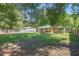 Expansive backyard featuring a wooden fence, mature shade trees, and a covered deck at 3065 Se 142Nd Ln, Summerfield, FL 34491