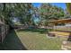 Expansive backyard featuring a covered deck, fire pit, and mature shade trees at 3065 Se 142Nd Ln, Summerfield, FL 34491