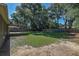 Large backyard with a wooden fence, patio area, and ample green space, perfect for entertaining and outdoor enjoyment at 3065 Se 142Nd Ln, Summerfield, FL 34491