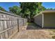 Narrow side yard features a wooden fence creating privacy, sandy ground cover and mature shade trees at 3065 Se 142Nd Ln, Summerfield, FL 34491
