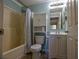 Relaxing bathroom is equipped with a shower-tub combo, toilet cabinet, and updated fixtures at 3065 Se 142Nd Ln, Summerfield, FL 34491