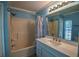 Bathroom showcasing a shower/tub combo, vanity, a mirror, and lighting at 3065 Se 142Nd Ln, Summerfield, FL 34491