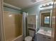 Cozy bathroom features neutral tones, a shower-tub combo, and convenient toilet cabinet at 3065 Se 142Nd Ln, Summerfield, FL 34491
