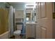 Well-lit bathroom with a shower/tub combo, toilet and vanity with storage at 3065 Se 142Nd Ln, Summerfield, FL 34491