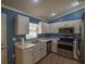 Stylish kitchen with stainless steel appliances, white cabinetry, and marble countertops at 3065 Se 142Nd Ln, Summerfield, FL 34491