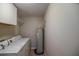Well-equipped laundry room includes washer, dryer, water heater, and built-in cabinets at 3065 Se 142Nd Ln, Summerfield, FL 34491
