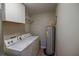 This laundry room features a washer, dryer, water heater, and convenient storage cabinets at 3065 Se 142Nd Ln, Summerfield, FL 34491