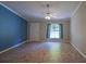 Bright living room with tile floors, a window with curtains, and a door, complemented by an accent wall at 3065 Se 142Nd Ln, Summerfield, FL 34491
