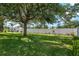 Large backyard features a white fence, mature trees, green grass, and well-maintained landscaping at 3612 Se 47Th Ter, Ocala, FL 34480