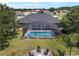 An expansive backyard includes a screened-in pool, fire pit area, and mature trees for outdoor enjoyment at 3612 Se 47Th Ter, Ocala, FL 34480